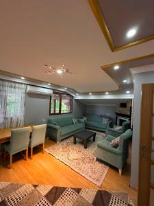 a living room with green couches and a table at Koç Motel in Uzungöl