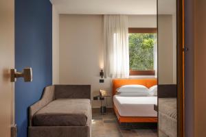 a bedroom with a bed and a chair and a window at Zurafa Resort in Terrauzza +41 photos