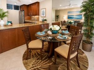a kitchen and dining room with a table and chairs at Mahana 604 Oceanfront 1BD 1BA condo in Kahana +19 photos