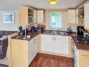 a kitchen with white cabinets and a counter top at 86 Cader Idris in Pwllheli