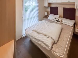a large white bed in a small room at 86 Cader Idris in Pwllheli