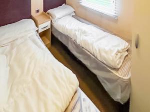 a room with two beds and a window at 86 Cader Idris in Pwllheli +2 photos