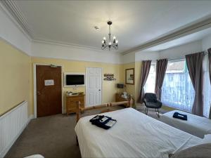 a bedroom with two beds and a desk and a television at The Beacon Hotel in Redcar