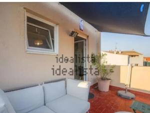 a living room with a white couch and a window at Where Mediterranean colours meets you in Terrassa
