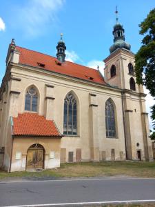a large church with a red roof at gemuetliche unterkunft bei prag in Smečno