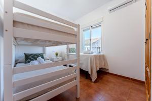 a bedroom with two bunk beds and a table at MalagaSuite Villa Flor de Piedra in Fuente de Piedra