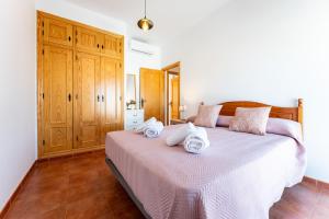 a bedroom with a bed with towels on it at MalagaSuite Villa Flor de Piedra in Fuente de Piedra
