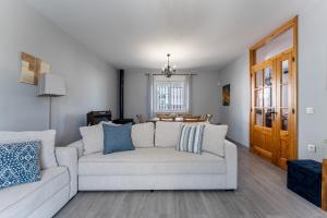 a living room with a white couch with blue pillows at MalagaSuite Villa Flor de Piedra in Fuente de Piedra +35 photos
