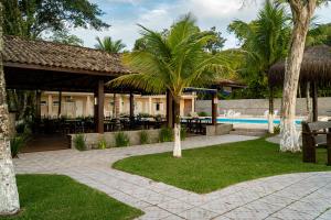 a resort with a swimming pool and palm trees at Summit Beach Hotel Boiçucanga in Boicucanga