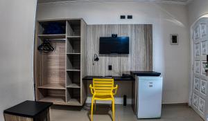 a desk with a yellow chair in a room at Summit Beach Hotel Boiçucanga in Boicucanga