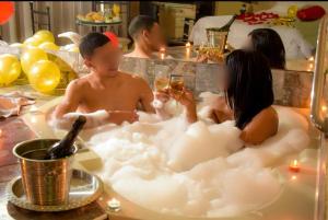 a couple of people in a bath tub with bubbles at Bellas Artes Palace Secret Suites Adult Only in Santiago +13 photos