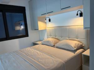 a bedroom with a white bed with a large headboard at L 32 Sea view in Lepetani