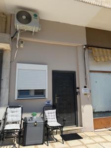 a porch with two chairs and a fan and a door at Athanias Studio in Drama