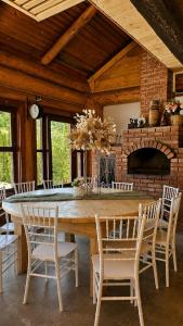 a dining room with a large wooden table and chairs at Cabana Perla Muncelului in Stulpicani