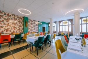 a dining room with tables and chairs and colorful walls at Hostellerie Bon Pasteur in Angers