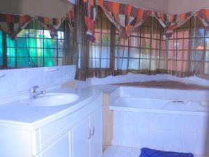 a bathroom with two sinks and stained glass windows at Kat Guest house in Northam