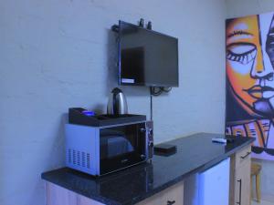 a microwave sitting on top of a counter with a tv at Kat Guest house in Northam +55 photos