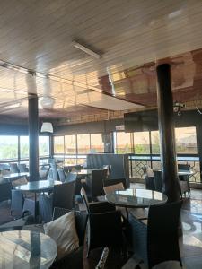 a dining room with tables and chairs and windows at The Sychar Palace Hotel in Kanga