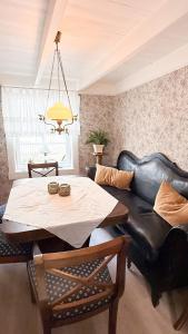 a living room with a black leather couch and a table at Charming and historic house in Flekkefjord