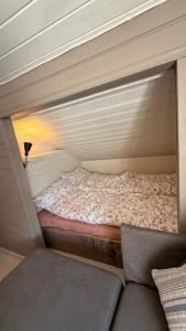 a small bed in a room with a couch at Charming and historic house in Flekkefjord