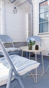 a table and two chairs on a porch with a table and flowers at Charming and historic house in Flekkefjord +39 photos