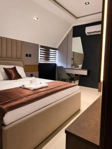 a bedroom with a large bed and a desk at La Topik Hotel & Suites in Otta