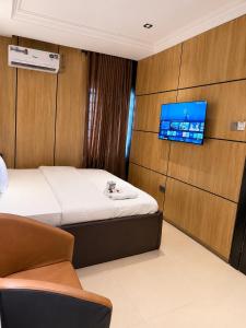 a room with a bed and a tv on a wall at La Topik Hotel & Suites in Otta