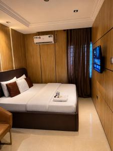 a bedroom with a bed and a television in it at La Topik Hotel & Suites in Otta