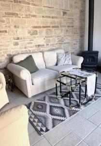 a living room with a couch and a brick wall at Èlpari Bed&Breakfast in Montelparo