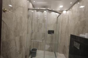 a shower with a glass door in a bathroom at The Brook Serene - A Nature Themed Boutique Resort, Kollam in Kottiyam