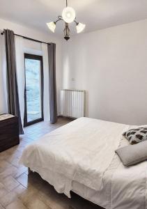 a bedroom with a large white bed and a window at Èlpari Bed&Breakfast in Montelparo