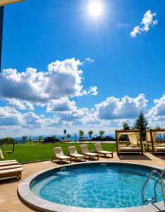 a pool with chaise lounge chairs and a patio at Alpina Lux in Kopaonik