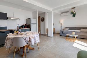 a kitchen and living room with a table and a couch at Casa Alena in Cervione