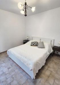 a bedroom with a white bed and a chandelier at Èlpari Bed&Breakfast in Montelparo