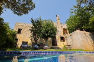 a house with a swimming pool in front of a building at Villa Fümehan Tarihi Rum Taş Ev Since 1820 in Kayakoy
