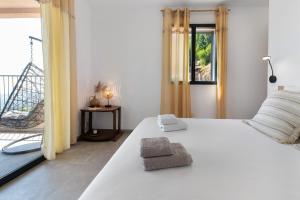 a bedroom with a white bed and a balcony at Casa Alena in Cervione