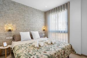 a bedroom with a large bed and a brick wall at Pinatar Luxury in San Pedro del Pinatar +29 photos