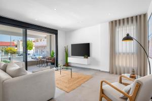 a living room with a couch and a tv at Pinatar Luxury in San Pedro del Pinatar