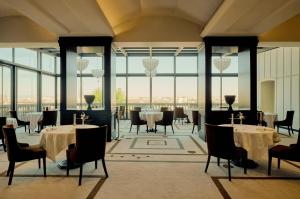 a restaurant with tables and chairs and large windows at Villa Florentine, A Beauvallon Hotel & Spa in Lyon