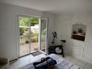 a room with a treadmill and a room with a window at le Refuge de Pia in Piégut-Pluviers
