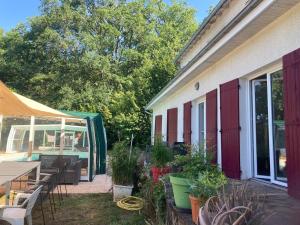 a patio with a table and chairs and plants at le Refuge de Pia in Piégut-Pluviers