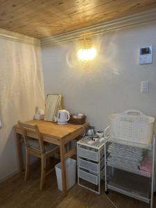 a room with a wooden desk and a table with a chair at Guest House "Ro"Hieda B101 in Shimonoseki