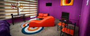 a living room with a red chair and purple walls at Bellas Artes Palace Secret Suites Adult Only in Santiago