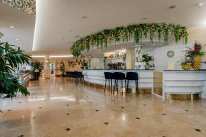 a lobby with a bar with chairs and plants at Hotel Roma Aurelia Antica in Rome +84 photos
