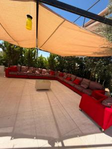 a patio with couches and chairs under a large umbrella at ANDA villa&Farm in Amman