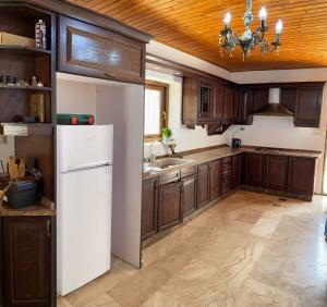 a kitchen with a white refrigerator and wooden cabinets at ANDA villa&Farm in Amman