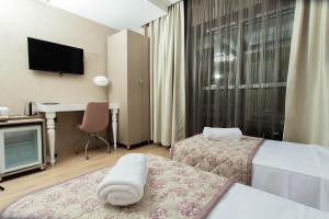 um quarto de hotel com duas camas e uma secretária em Hotel Iz em Esmirna