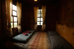 a bedroom with a bed in a room with windows at Anka Köy Evi in Çamlıhemşin