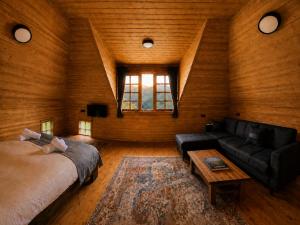 a bedroom with a bed and a couch and a table at Anka Köy Evi in Çamlıhemşin