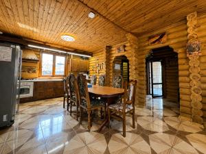 a kitchen with a wooden table and chairs at Дом рыбака Маяки Ватер Сити Днестр in Mayaki
